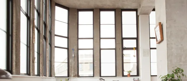 Estancia con ventanales altos de marco blanco tras una remodelación
