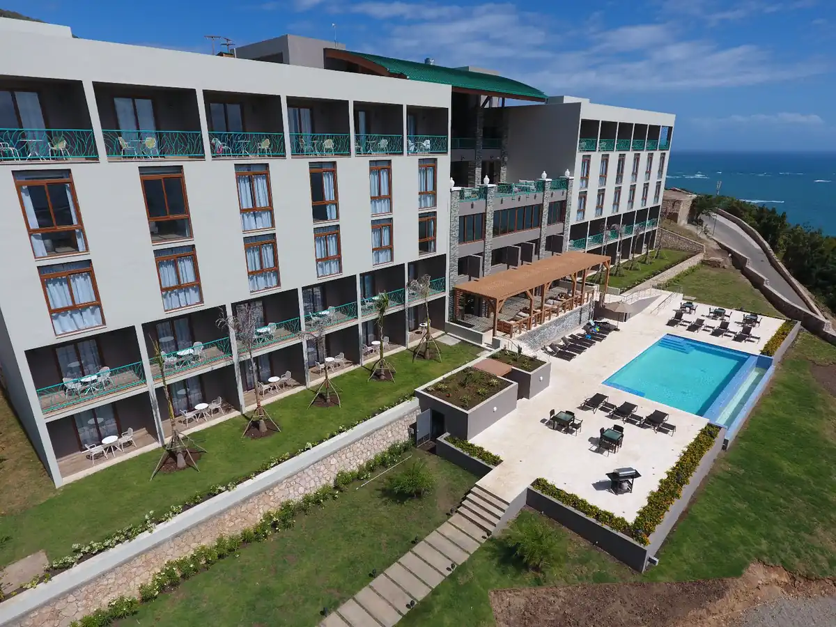 Vista aérea de un desarrollo hotelero frente al mar con cancelería de gran formato en todas sus fachadas