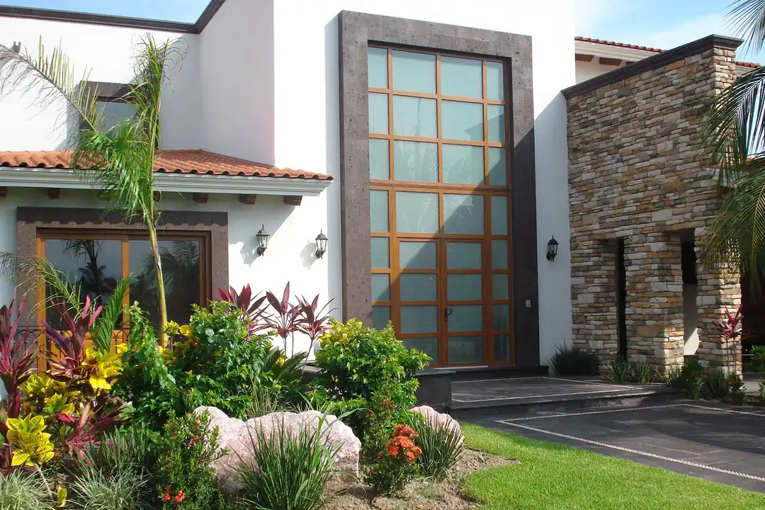 Acceso residencial con cancelería de doble altura y despiece a medida