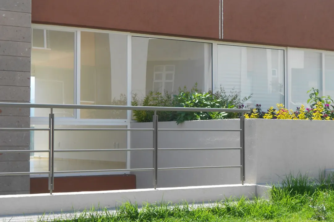Fachada corrida de un desarrollo con ventanas de PVC repetidas a lo largo de todo el paño