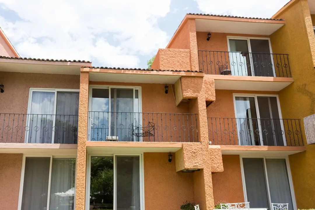 Edificio residencial de varios niveles con balcones y cancelería de PVC en cada departamento