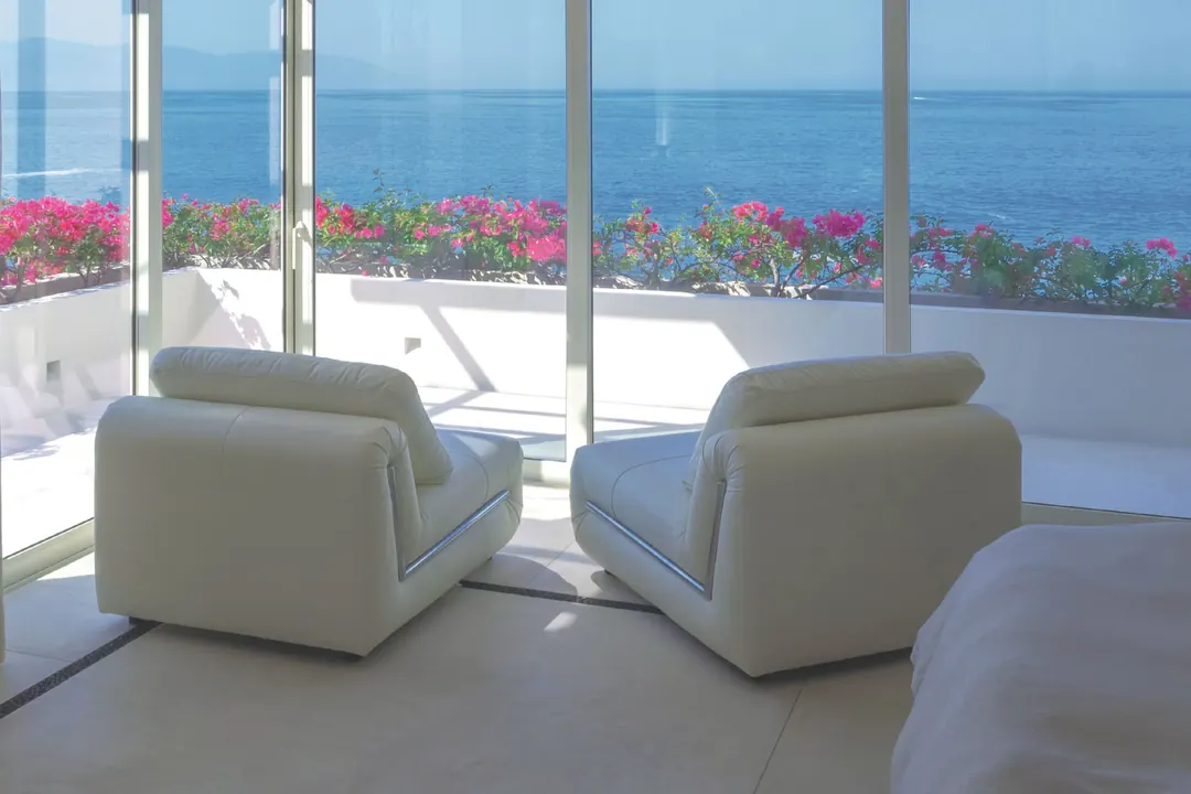 Estancia con cancelería panorámica de piso a techo frente al mar