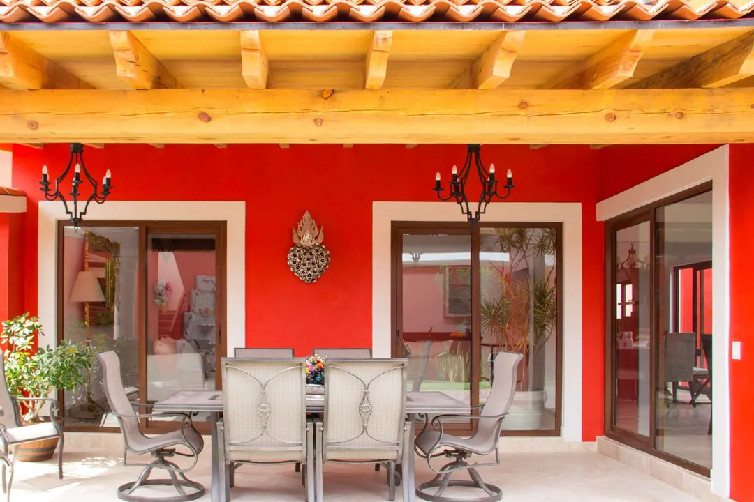 Terraza mexicana con viga de madera y puertas corredizas hacia el comedor exterior