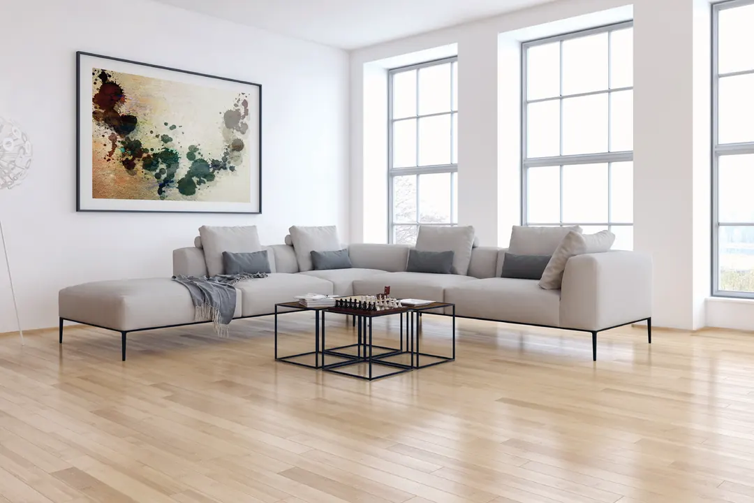 Sala luminosa con ventanas altas de marco blanco y piso de madera clara