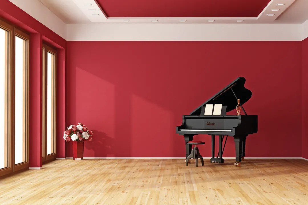 Sala de muro rojo con ventanal de piso a techo y marco blanco sobre piso de madera clara